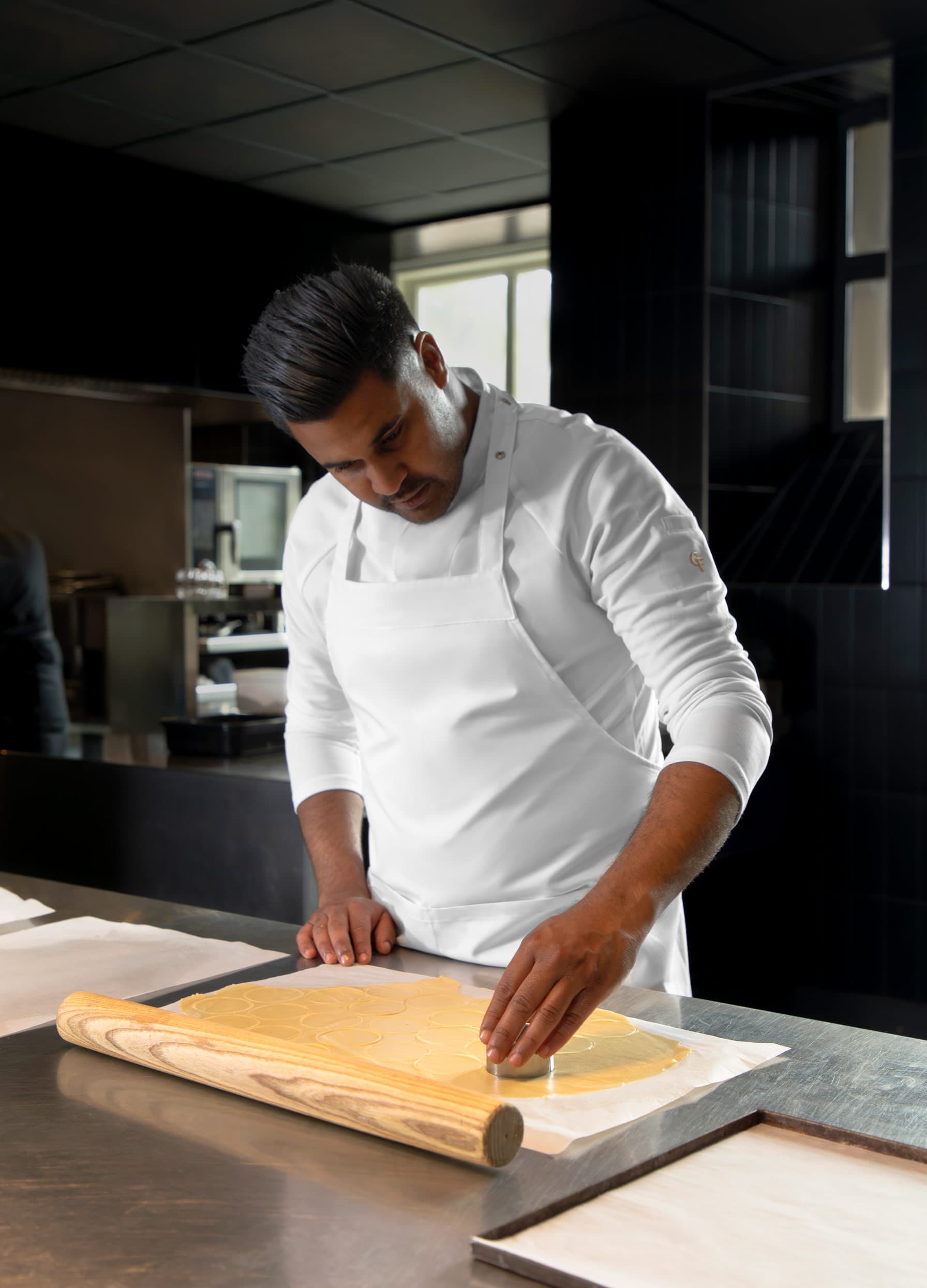 Chef aan het werk in een witte Cheffix koksbuis
